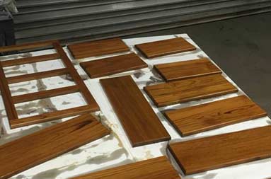 The faces of the drawers are laid out on the table, just after being treated.