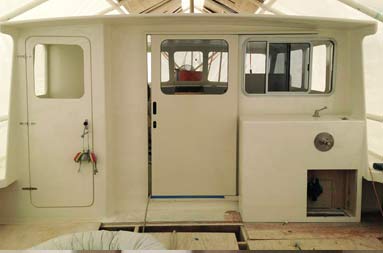 View from deck looking towards the front of the boat at the deckhouse with the door closed