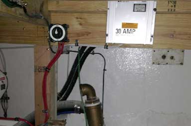 View down below inside the boat of battery charger and other electrical wires.