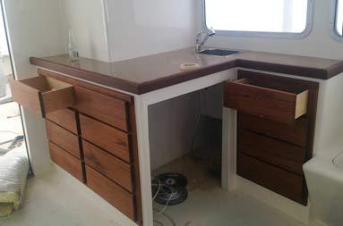 Interior view of wooden countertop and drawers with teak trim