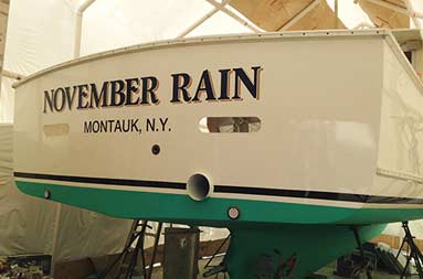 View from ground level looking slightly up of the back of the boat with the November Rain name and Montauk, NY underneath in smaller letters