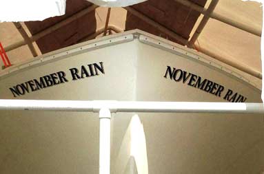 View from ground level looking slightly up at the front of the boat with the November Rain name painted on both sides
