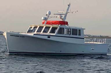 View from ground level looking slightly up at the front of the boat with the November Rain name painted on both sides