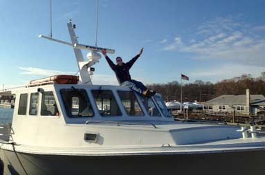 Capt. Steve sitting on top of the boat, looking small in comparison