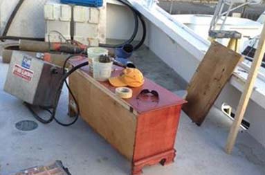 The deck of the boat with equipment, parts of the boat, and other pieces scattered around