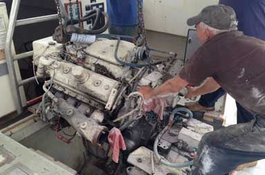 Capt. Steve and two men from T&S Marine continue lifting as they prepare to move the engine 