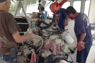 Capt. Steve and two men from T&S Marine now start to move the engine where it will temporarily sit on blocks