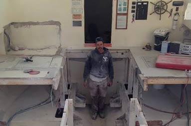 View of Capt Steve standing inside the boat where the new deckhouse will be,making him look very small in comparison to the rest of the boat.