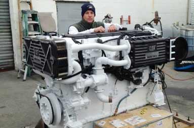 Captain Steve bundled up standing next to the engine propped on a wood platform