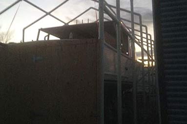 Wooden back door entrance is constructed within the frame, before the tent is put up