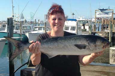 Patty back at the marina, holding up the large bluefish she caught