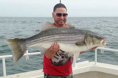 One of the guys on the boat, holding up the large bass he caught.