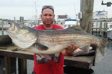 One of the guys back at the marina, holding up the large bass he caught.