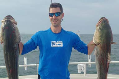 Two large bass lying on the deck of the boat