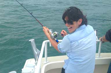 Alex is hooked into her own bass as she looks back over her shoulder laughing into the camera