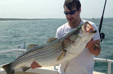 One of the guys holding up the large bass he caught on the boat