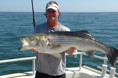 One of the guys standing on the boat holding a large bass he caught
