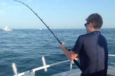 Rear shot of one of the guys reeling in a fish