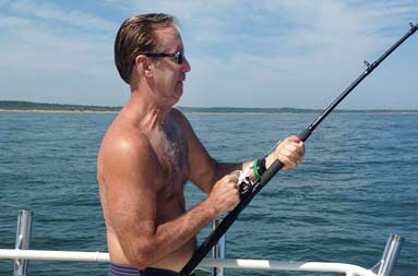 One of the guys, Marshall, holding onto the rod ready to reel in a fish.