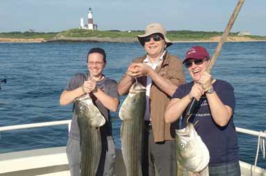 The group of 3 each hold up their catch aboard the November Rain