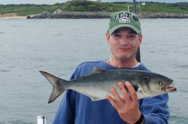 One of the guys holding up a small bluefish that he caught