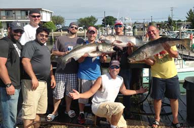 All of the guys back at the marina holding up their catch, and Capt Steve kneeling down in front