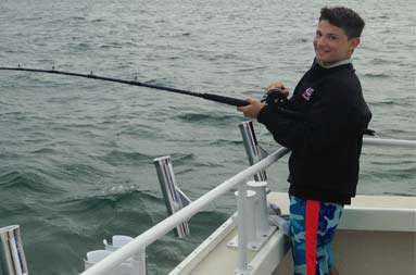One of the young boys, Jacob, reeling in a fish