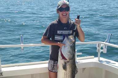 One of the triplets, Julie, holds up her catch