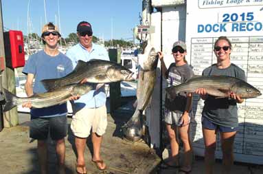 Father Matt, and the triplets back at the marina each holding up their catch