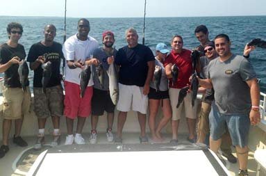 Group photo of all the guys on the trip, some holding up their catch