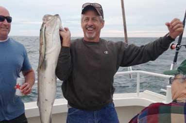 One of the guys holding up his line with 2 fish caught on it