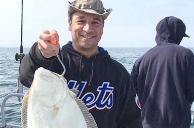 One of the guys of the group, George, holding up a good sized fluke.