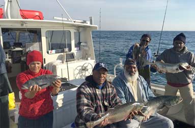 Five men on the boat proudly show off the their catch.