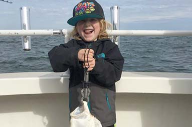 A young boy proudly shows off this flatty which he just caught with his dad.