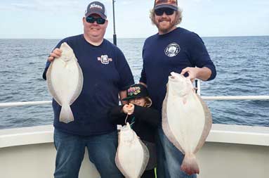 Group photo with some of today's catch of fluke.