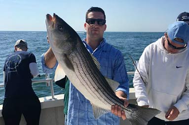 Another man holding up the fish he caught..
