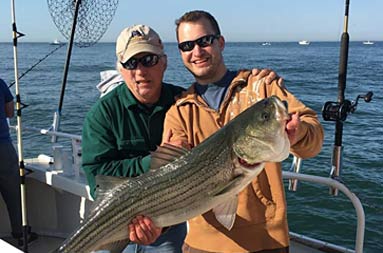 Two men holding up the fish they caught.