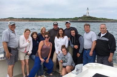 A group of 12 men and women on the boat smiling for the camera.