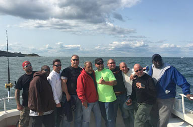 Ten men gather together and smile for the camera.