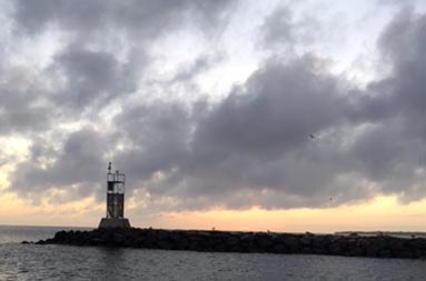 A photo of a buoy at the inlet at dusk.