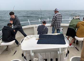 A group of men setting up their reels and preparing to catch some fish.